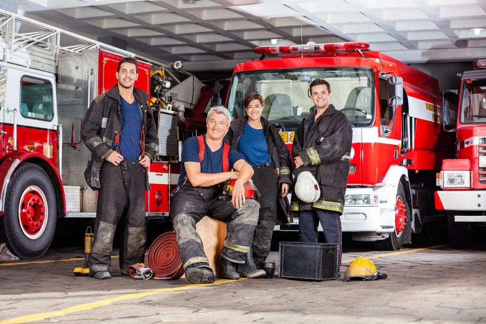 A group of people standing next to a fire truck.